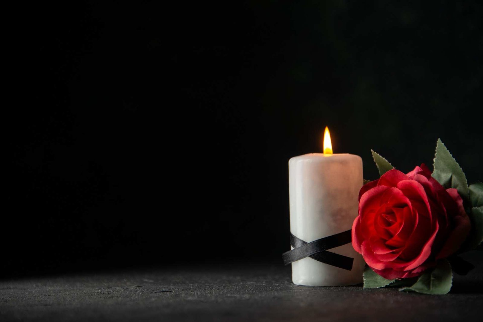 white-candles-with-red-flower-dark-wall
